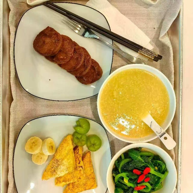 Postpartum meal tray: millet congee, tofu, greens and fruit