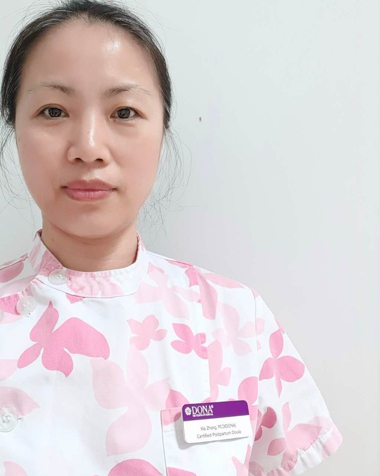 Rainy in her postpartum doula uniform wearing her DONA International name badge